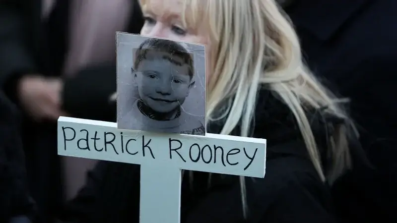 Patrick Rooney's sister Sharon Moore holds a cross with his photo on it at a Time for Truth campaign march in Belfast